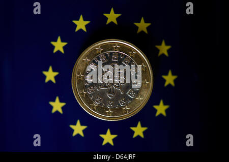 Die Abbildung zeigt die portugiesische Ausgabe des ein-Euro-Münze auf dem Display auf ein Emblem mit dem Symbol der Europäischen Union in Dresden, Germaany, 23. April 2012. Foto: Arno Burgi Stockfoto