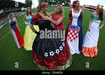 Mode-Designerin Manuela Offenborn aus Herrnburg (C) passt das Ballkleid für Deutschland im Lohmuehle Stadion in Lübeck, 29. Mai 2012. Models präsentierten Ballkleider in den Farben von den Teilnehmerländern der UEFA Fußball-Europameisterschaft 2012. Mode-Designerin Manuela Offenborn aus Herrnburg entworfen und genäht Ballkleider in den Farben der 16 participati Stockfoto