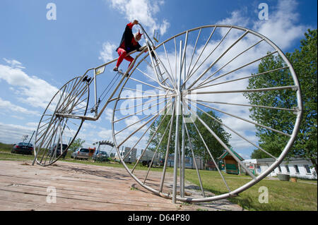 Fahrrad-Designer Dieter (Didi) Senft sitzt auf entsprechende Berichte von seinem Erbauer, "größte funktionelle Fahrrad der Welt" in Pudagla, Deutschland, 1. Juni 2012. Didi Fahrrad ist 7,80 Meter lang, 3,70 Meter hoch, mit einem Radradius von 3,32 m und wiegt 150 kg. Bis jetzt hatte er 17 Guiness-Buch-Rekorde. Das Motorrad ist Teil einer Sonderausstellung im Museum "Wo Stockfoto