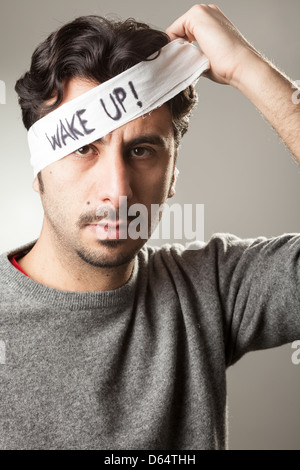Mann ausziehen eine Binde von den Augen mit "Wake Up!" Darauf geschrieben Stockfoto