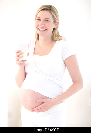 Schwangere Frau Trinkmilch Stockfoto