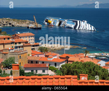 Das gekenterte Kreuzfahrtschiff Costa Concordia liegt der Hafen von Giglio Insel (Isola del Giglio), Italien, 17. Mai 2012. Das Kreuzfahrtschiff liegt halb versunkenen vor der Insel Giglio, nachdem es Unterwasser Felsen am 13. Januar 2012 getroffen. Nach der "de-Betankung" Prozess zielte die Vermeidung von verschütten und die Kontamination eines der unberührtesten natürlichen Sanctuarie des Mittelmeers Stockfoto