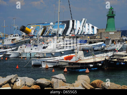 Das gekenterte Kreuzfahrtschiff Costa Concordia liegt der Hafen von Giglio Insel (Isola del Giglio), Italien, 24. Mai 2012. Das Kreuzfahrtschiff liegt halb versunkenen vor der Insel Giglio, nachdem es Unterwasser Felsen am 13. Januar 2012 getroffen. Nach der "de-Betankung" Prozess zielte die Vermeidung von verschütten und die Kontamination eines der unberührtesten natürlichen Sanctuarie des Mittelmeers Stockfoto