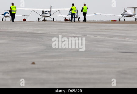 Arbeiter stehen auf dem Vorfeld des Flughafens Rostock-Laage, Deutschland, 15. Juni 2012. Nach neun Monaten ist die neue Schürze des Flugplatzes abgeschlossen. 12 000 mehr Quadratmetern bieten Parkplätze für Flugzeuge. Der Bau kostet rund 3,1 Millionen Euro und 90 Prozent davon wurden von der Gemeinde finanziert. Foto: JENS Büttner Stockfoto