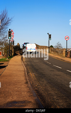 Datenverkehr über die alte mittelalterliche Brücke über den Norfolk Broads in Potter Heigham, Norfolk, England, Vereinigtes Königreich. Stockfoto