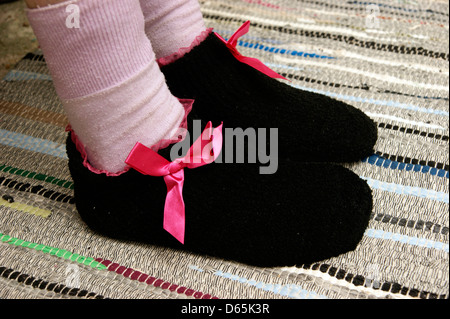 Ältere Frau tragen Socken & gestrickte Hausschuhe, halten warm und gemütlich im winter Stockfoto