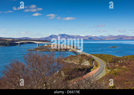 SKYE BRIDGE UND LOCH ALSH MIT SCHNEE BEDECKT CUILLIN BERGE AUF EINER FRÜHEN FRÜHLINGSTAG, WEST COAST SCHOTTISCHES HOCHLAND Stockfoto