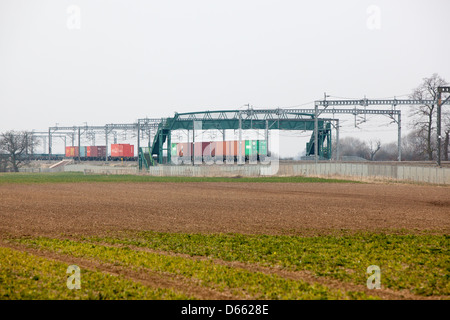 Container Fracht Reisen entlang der West Coast Mainline Railway durch die Midlands. Intermodaler Verkehr genannt. Stockfoto