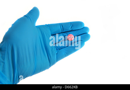 Hand im Handschuh hält Pille für die Liebe auf weißem Hintergrund Stockfoto