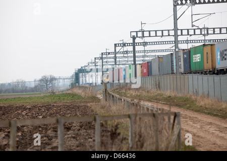 Container Fracht Reisen entlang der West Coast Mainline Railway durch die Midlands. Intermodaler Verkehr genannt. Stockfoto