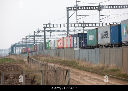 Container Fracht Reisen entlang der West Coast Mainline Railway durch die Midlands. Intermodaler Verkehr genannt. Stockfoto