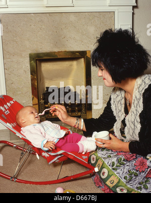 Junge weibliche Kindermädchen Fütterung neun Monate altes Baby, Highgate, Nord-London, England, Vereinigtes Königreich Stockfoto
