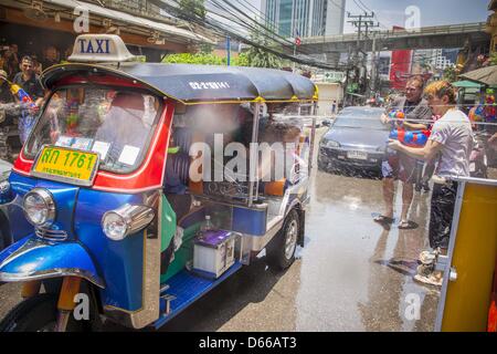 Bangkok, Thailand. 13. April 2013.  Thais und Touristen werfen Wasser auf Touristen in einem '' Tuk-Tuk"(drei Rädern Taxi) während Songkran Feierlichkeiten auf Soi Nana, Sukhumvit Road in Bangkok. Songkran ist in Thailand als der traditionelle Tag des neuen Jahres von 13 bis 16 April gefeiert. Das Datum des Festivals war ursprünglich durch astrologische Berechnung, aber es ist nun behoben. Wenn die Tage auf ein Wochenende fallen, werden die verpassten Tage werktags sofort nach. Alamy. Stockfoto