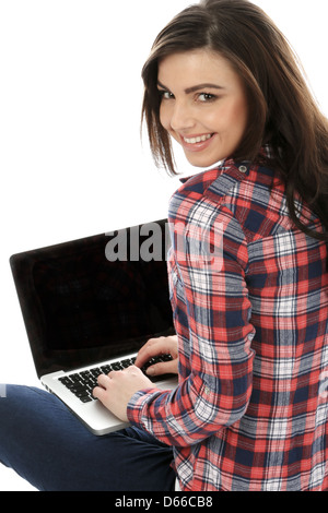 Junge Frau, die allein auf dem Boden sitzt und mit EINEM Laptop arbeitet, arbeitet remote zu Hause im Internet und isoliert von Coronavirus Stockfoto