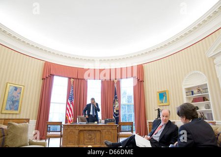 US-Präsident Barack Obama spricht am Telefon mit Präsident Vladimir Putin in Russland aus dem Oval Office 1. März 2013 in Washington, DC. National Security Advisor Tom Donilon spricht mit Tony Blinken, stellvertretender nationaler Sicherheitsberater, rechts im Vordergrund. Stockfoto