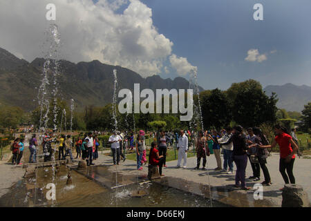 Srinagar, indische Kaschmir. 13. April 2013 - Kashmiri Menschen genießen die Gischt der Brunnen im Nishat Mughal Garten mit Blick auf den berühmten Dal-See in Srinagar. während eines Urlaubs markiert das Fest der Baisakhi. Baisakhi, welcher am 14. April gefeiert wird, markiert den Beginn der Erntezeit in Nordindien. (Kredit-Bild: © Altaf Zargar/ZUMAPRESS.com) Stockfoto