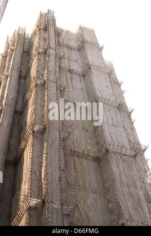 Bambus, Gerüste und netting umfasst ein Gebäude renoviert in Hong Kong Stockfoto