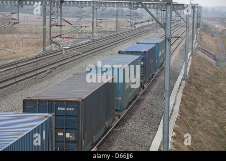 Container Fracht Reisen entlang der West Coast Mainline Railway durch die Midlands. Intermodaler Verkehr genannt. Stockfoto