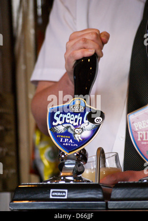 Der Barkeeper zieht ein Pint von Castle Rock Brauerei, Nottingham creech Eule "bitter aus einer Handpumpe pub Tabelle getränke Gläser Stockfoto