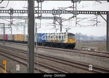 Container Fracht Reisen entlang der West Coast Mainline Railway durch die Midlands. Intermodaler Verkehr genannt. Stockfoto