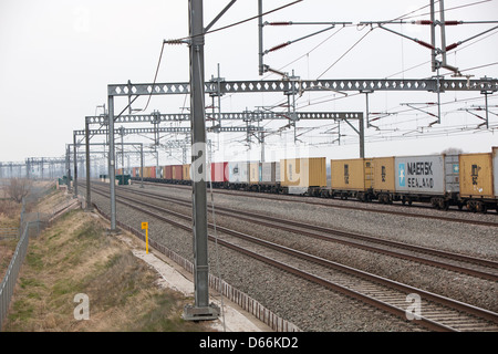 Container Fracht Reisen entlang der West Coast Mainline Railway durch die Midlands. Intermodaler Verkehr genannt. Stockfoto