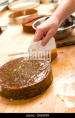 Männlichen Chef dekorieren Schokoladenkuchen in der Küche Stockfoto