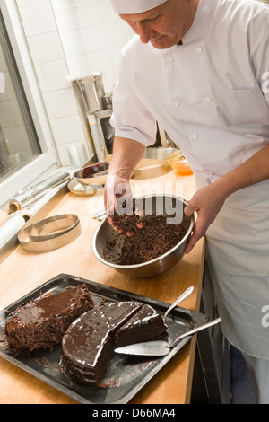 Kochen Sie hinzufügen von Schokoladensauce mit Händen, um in Küche Kuchen Stockfoto