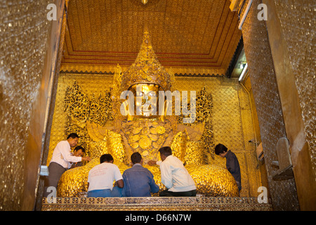 Gläubige, die Anwendung von Blattgold auf Mahamuni Buddha, Mahamuni Pagode, Mandalay, Myanmar (Burma) Stockfoto