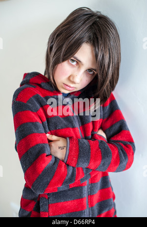 Junge weiße dunkelhaarige Mädchen sieht traurig, wütend, verletzlich und aufgeregt, Blick auf die Kamera und weg von der Kamera trägt ein rot-graues Sweatshirt Stockfoto