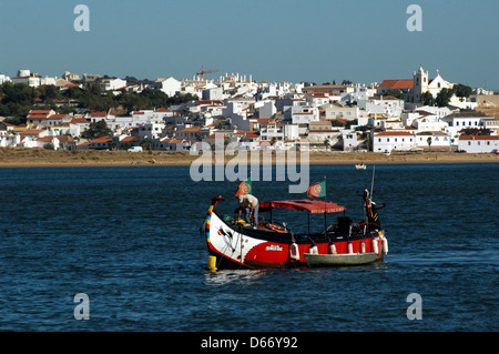 Ein Sightseeing-Boot, das entlang des Flusses Arade navigiert, mit Blick auf die Stadt Ferragudo im Hintergrund, an der westlichen Grenze der Gemeinde Lagoa in der Algarve, der südlichsten Region Portugals Stockfoto