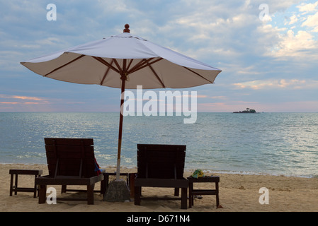 Zwei Betten und ein Sonnenschirm am Strand bei Sonnenuntergang. Koh Chang, Thailand. Stockfoto