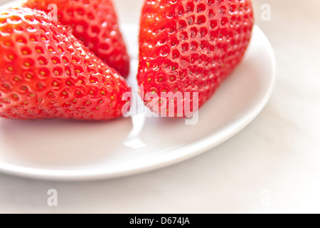 Drei Erdbeeren auf den weißen Teller Stockfoto