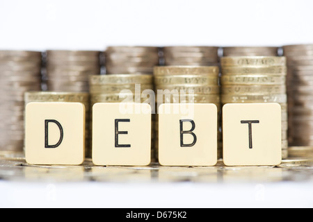 Das Wort Schulden vor Stapel von Englisch zwanzig Pence und 1 Pfund Münzen Stockfoto
