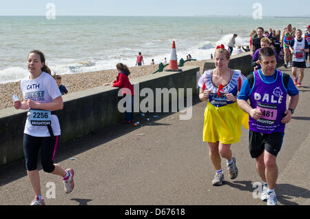 Brighton, UK. 14. April 2013. Brandung bricht am Ufer neben ihnen als Läufer in Richtung Heimat entlang der Promenade in Hove in Brighton Marathon Phot Credit: Julia Claxton/Alamy Live News Stockfoto