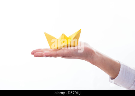 Isolierten weiblichen Hand hält ein Schiff auf weiß. Stockfoto