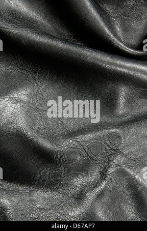 Nahaufnahme der zerknitterten glänzenden schwarzen Leder-Textur. Stockfoto