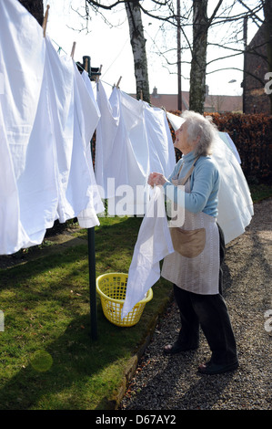 Ältere Rentner eine Linie des Waschens auf ihrer Wäscheleine im April hängen. Stockfoto