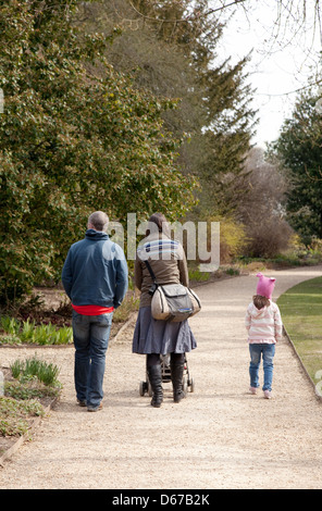 Eine Familie, die zu Fuß in den Park, Mutter Vater und Kind gesehen von hinten, UK Stockfoto