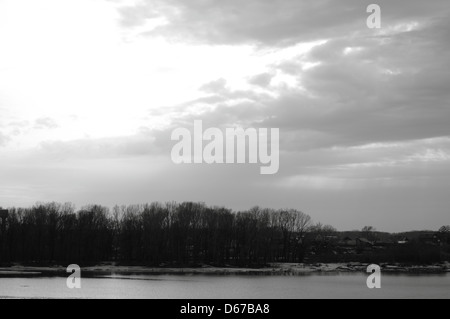Ein Schwarzweißbild des schmelzenden Eises auf einem Fluss in Russland im Frühling. Die Szene fängt den Übergang vom Winter zum Frühling ein, wobei fließendes Wasser und Eis im Fluss schmelzen. Stockfoto