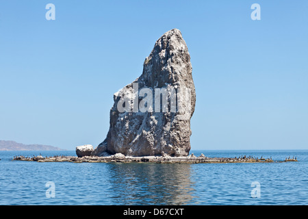 Roca Solitaria, einem Felsvorsprung und Seevogel-Kolonie von Agua Verde, Baja California Sur, Mexiko, mit braunen Pelikane an der Basis. Stockfoto