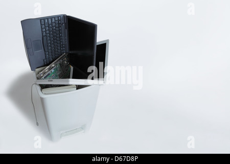 in den Papierkorb sehen wir zwei Laptops und elektronische Bauteile (Hauptplatine oder Prozessor). Textfreiraum. Stockfoto