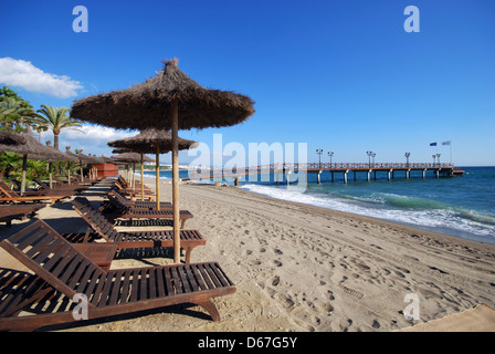 Leere Liegestühle und Sonnenschirm am Strand, daitona Beach, Marbella, Costa del Sol, Provinz Malaga, Andalusien, Spanien. Stockfoto