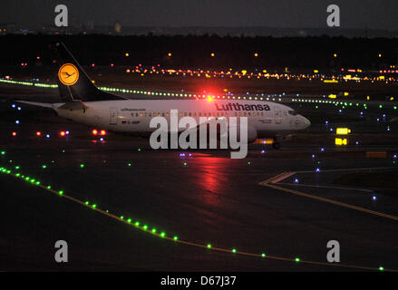 Ein Passagier-Flugzeug der Fluggesellschaft Lufthansa bereitet sich auf für einen Nachtflug am Frankfurter Flughafen in Frankfurt Main, Deutschland, 3. Januar 2012 abheben. Ein striktes Verbot von Nachtflügen ist in Kraft seit Oktober an Deutschlands größtem Flughafen. Lärmbelästigung durch Demonstranten beschweren sich über zu viele Ausnahmen, während Lufthansa 23:00 Termin loswerden möchte. Foto: Boris Roessler Stockfoto