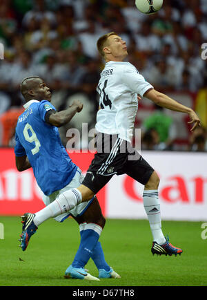 Deutschlands Holger Badstuber (R) wetteifert für der Ball mit Italiens Mario Balotelli für die UEFA EURO 2012 Halbfinale Fußball match Deutschland vs. Italien im Nationalstadion in Warschau, Polen, 28. Juni 2012. Foto: Andreas Gebert Dpa (siehe Kapitel 7 und 8 der http://dpaq.de/Ziovh für die UEFA Euro 2012 Geschäftsbedingungen &) +++(c) Dpa - Bildfunk +++ Stockfoto