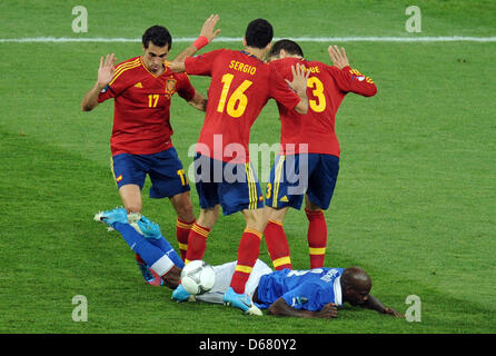 Italiens Mario Balotelli (am Boden) wetteifert um den Ball mit Spaniens Alvaro Arbeloa (L-R), Sergio Busquets und Gerard Pique während der UEFA EURO 2012 final Fußball Spiel Spanien vs. Italien im Olympiastadion in Kiew, Ukraine, 1. Juli 2012. Foto: Thomas Eisenhuth Dpa (siehe Kapitel 7 und 8 der http://dpaq.de/Ziovh für die UEFA Euro 2012 Geschäftsbedingungen &) +++(c) Dpa - Bil Stockfoto