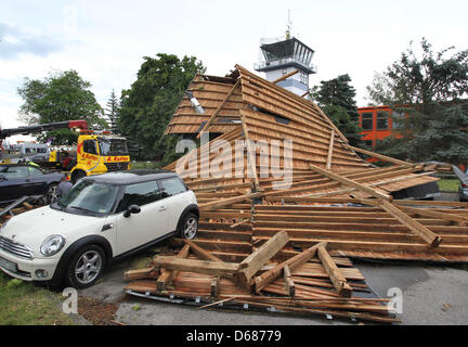 Mitarbeiter von Auto Abschleppdienst retten ein Auto aus den Trümmern eines Daches in Memmingen, Deutschland, 6. Juli 2012. Schwere Stürme hatten vom Dach des Verwaltungsgebäudes am Flughafen Memmingen durchgeführt, die dann mehrere Autos beschädigt. Foto: Karl-Josef Hildenbrand Stockfoto