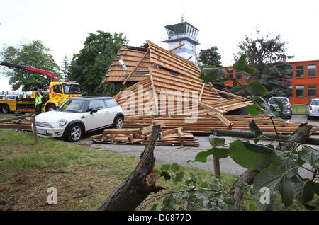 Mitarbeiter von Auto Abschleppdienst retten ein Auto aus den Trümmern eines Daches in Memmingen, Deutschland, 6. Juli 2012. Schwere Stürme hatten vom Dach des Verwaltungsgebäudes am Flughafen Memmingen durchgeführt, die dann mehrere Autos beschädigt. Foto: Karl-Josef Hildenbrand Stockfoto