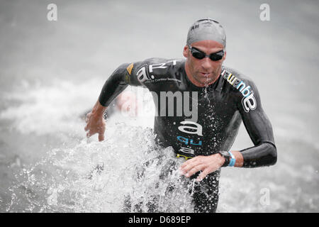 Während des Ironman Frankfurt ist französische Triathlet Stephane Poulat der erste Abschnitt schwimmen am Langener Waldsee in Frankfurt Am Main, Deutschland, 8. Juli 2012 beenden. Tausende von Triathleten nehmen Teil an dem Wettbewerb, der 3,8 km Schwimmen, 180 km Radfahren und 42,2 km laufen enthält. Foto: Fredrik von Erichsen Stockfoto