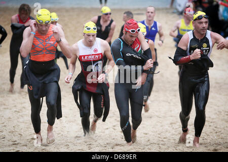 Während des Ironman Frankfurt Triathleten aus ihren Badeanzügen befreien Sie nach Beendigung der Abschnitt "schwimmen" am Langener Waldsee in Frankfurt Am Main, Deutschland, 8. Juli 2012. Tausende von Triathleten nehmen Teil an dem Wettbewerb, der 3,8 km Schwimmen, 180 km Radfahren und 42,2 km laufen enthält. Foto: Fredrik von Erichsen Stockfoto