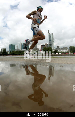 Während des Ironman Frankfurt führt ein Triathlet vorbei an der Skyline in Frankfurt Am Main, Deutschland, 8. Juli 2012. Tausende von Triathleten nehmen Teil an dem Wettbewerb, der 3,8 km Schwimmen, 180 km Radfahren und 42,2 km laufen enthält. Foto: Fredrik von Erichsen Stockfoto